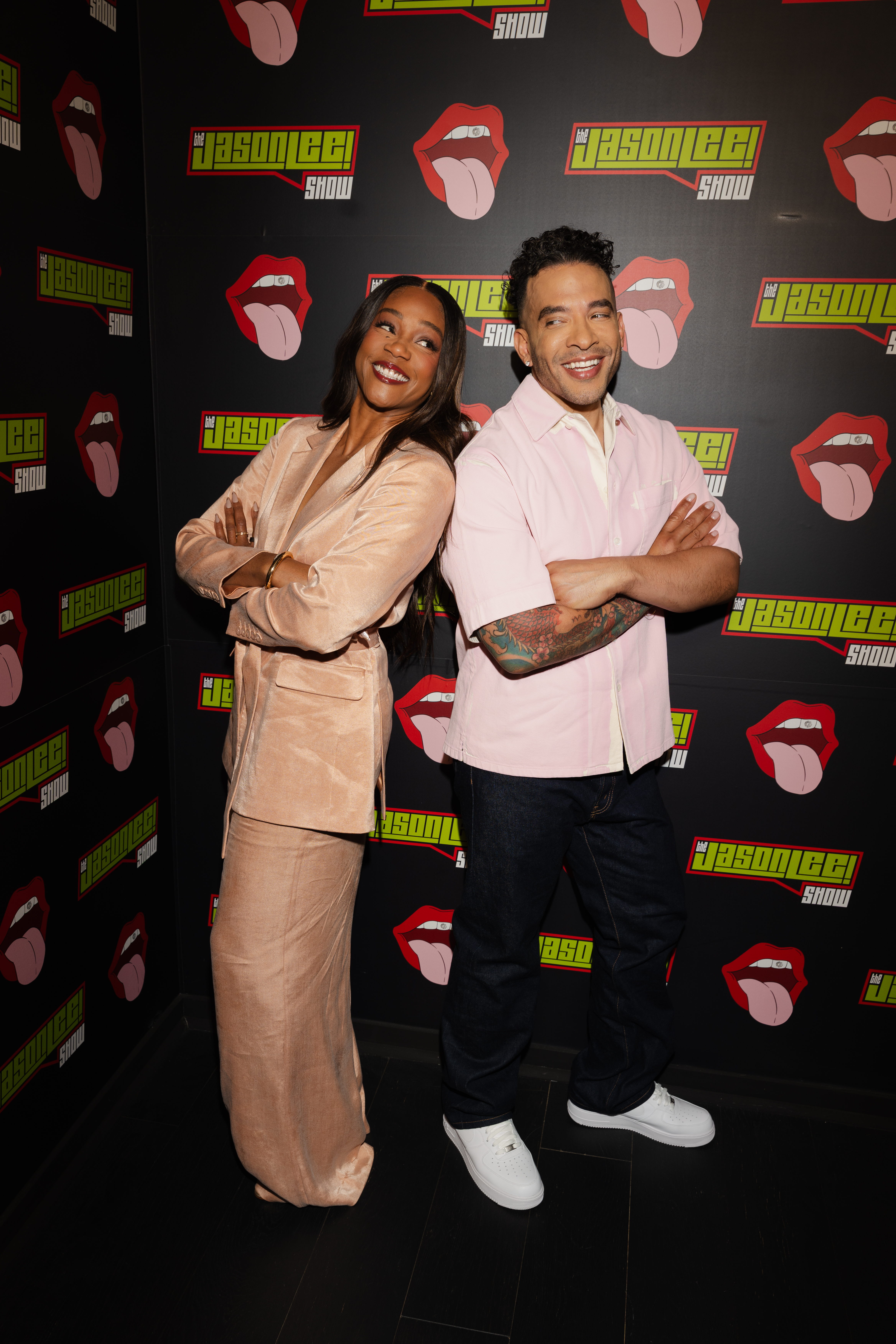 Two guests posing at The Jason Lee Show backdrop
